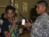 Joseph Sweatt, an honor roll student with Clarksville’s West Creek Middle School, and Sgt. Jose Morales, a communications specialist with the 218th Military Police Company, 716th Military Police Battalion, 101st Sustainment Brigade, 101st Airborne Division, talk through hand-held radios used by Fort Campbell’s military police during a visit to Fort Campbell, Ky., from the WCMS honor roll students May 15, 2015. (Sgt. 1st Class Mary Rose Mittlesteadt, 101st Sustainment Brigade, 101st Airborne Division (Air Assault) Public Affairs)