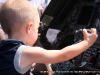 A child sits behind the controls of a helicopter