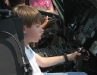 A child sits behind the controls of a helicopter
