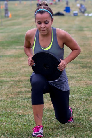 Autumn Gonzalez, a military spouse and employee at the Fort Campbell Child and Youth Services, lunges with 25 pounds across a 30 meter course as part of the 2014 Eagle Challenge Fitness Tour Functional Fitness Challenge July 19, at Fort Campbell. (Leejay Lockhart)