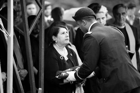 A Soldier assigned to the 101st Airborne Division presents a folded American flag to Virginia Mampre, the daughter of Staff Sgt. Al Mampre, during graveside services at Memorial Park Cemetery in Skokie on Saturday, June 15, 2019. Mampre served as a medic with Easy Company, 2nd Battalion, 506th Parachute Infantry Regiment, 101st Airborne Division during World War II. (Sgt. David Lietz) 