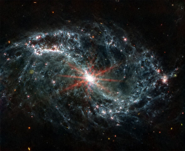 The spiral arms of galaxy NGC 7496 are filled with cavernous bubbles and shells overlapping one another in this image from MIRI. These filaments and hollow cavities are evidence of young stars releasing energy and, in some cases, blowing out the gas and dust of the interstellar medium surrounding them. (NASA, ESA, CSA, and J. Lee (NOIRLab). Image processing: A. Pagan (STScI))
